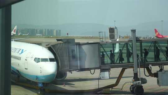 机场登机廊桥乘客玻璃登机桥上行走的乘客