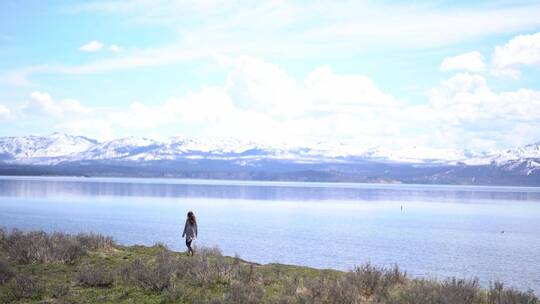 一个女人在湖边散步欣赏风景视频素材模板下载