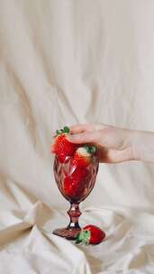 装满一杯草莓，用手拿起一个