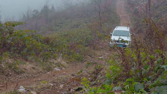 冬季山乡冰雪泥泞山路上艰难行驶的越野车