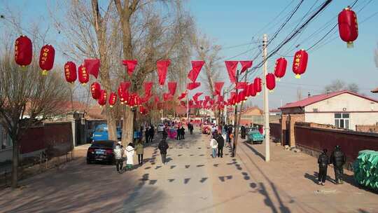 乡村街道悬挂红灯笼人群走动