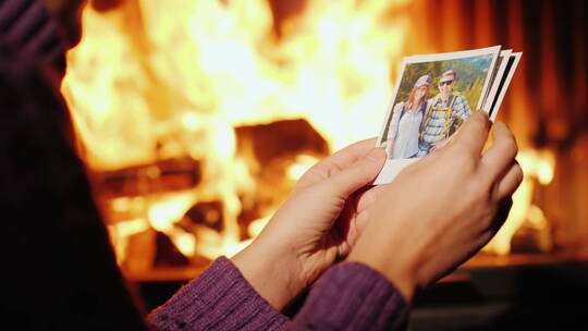 女人坐在壁炉前看度假时的照片