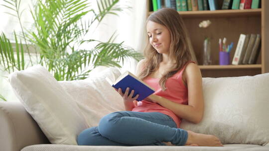 女孩坐在沙发上看书