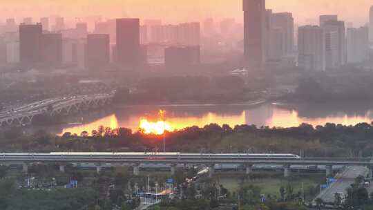 航拍夕阳高铁行驶桥梁河流车流建筑群高楼