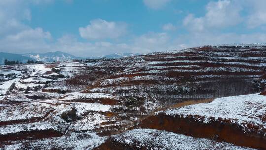 冬季白雪覆盖红土地山川田野远处连绵雪山