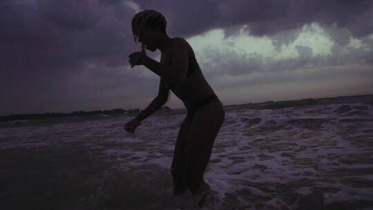 女孩在乌云密布的大海中游泳