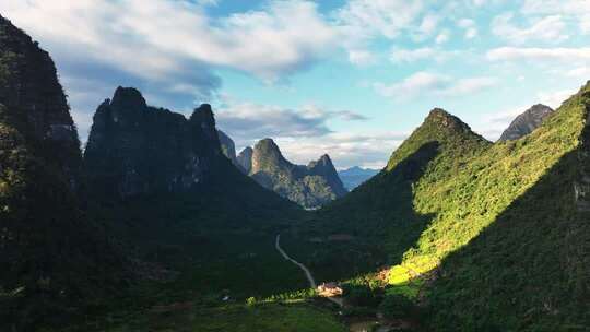 日出阳光下广西贺州山谷中的乡村公路和房屋