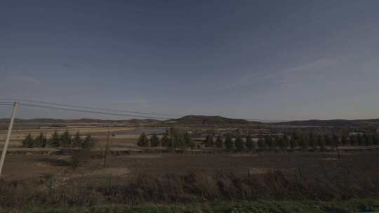 秋天行驶的车窗外风景田地枯树河流窗外风景