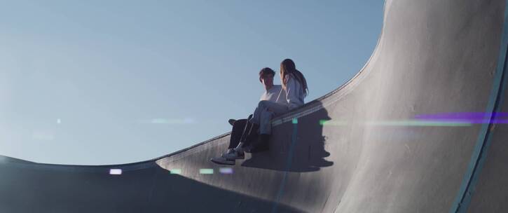 坐在滑板场所的情侣