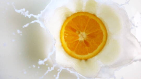 橘子片落入新鲜的牛奶中