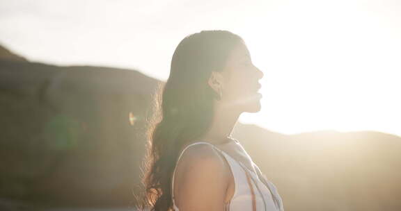 女人，呼吸和思考户外和平的未来，在日落时