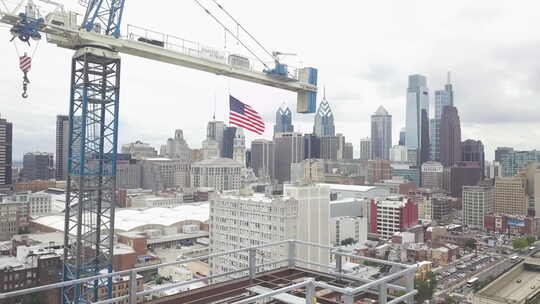 放大到费城摩天大楼，一面美国国旗从建筑起重机上飘扬。