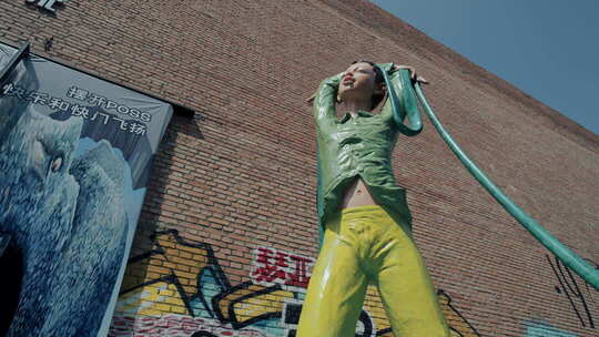 绿色布料包裹的雕像与涂鸦墙