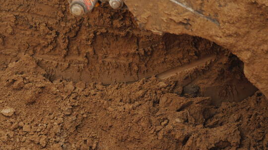 挖掘机铲斗从沟槽中铲出土壤