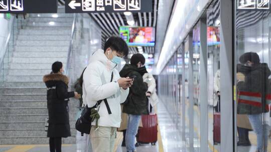 地铁站乘客玩手机候车