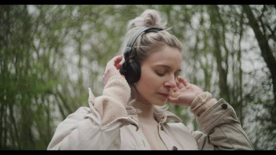 女人戴着耳机听音乐视频素材模板下载