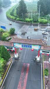 中式牌坊下的道路雨中景象