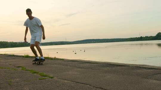 男青年在湖边玩滑板