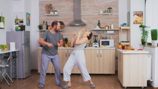 有趣的夫妇在厨房跳舞