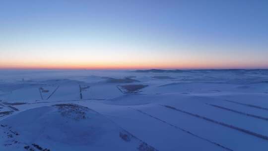 航拍严冬中的辽阔暮色雪原