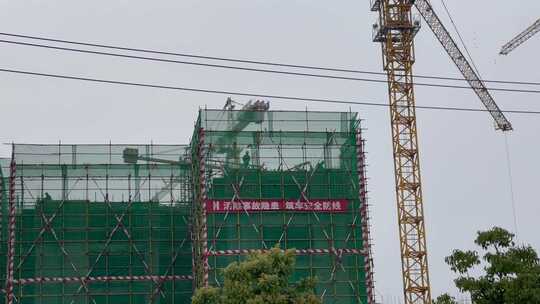 建筑工地安全帽施工的工人塔吊
