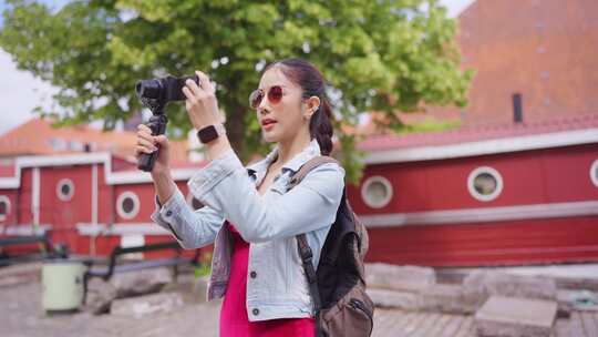 亚洲女性旅行者在城市旅行时使用相机记录v