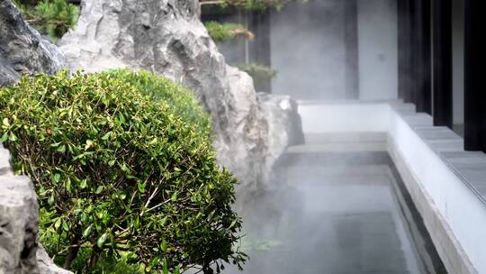 中式合院内烟雾升腾的景观池