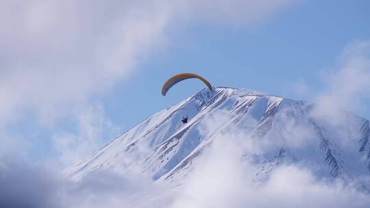 雪山上滑滑翔伞的人