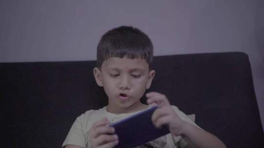 小男孩沙发上玩手机画面