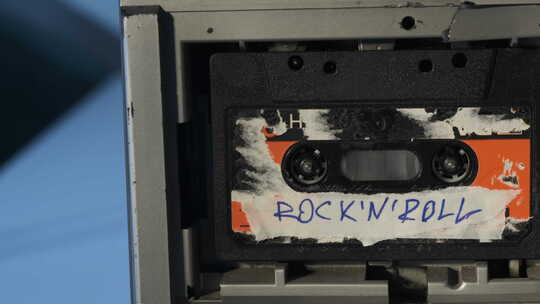 旧收音机中播放带有撕裂贴纸的旧二手黑色磁带视频素材模板下载