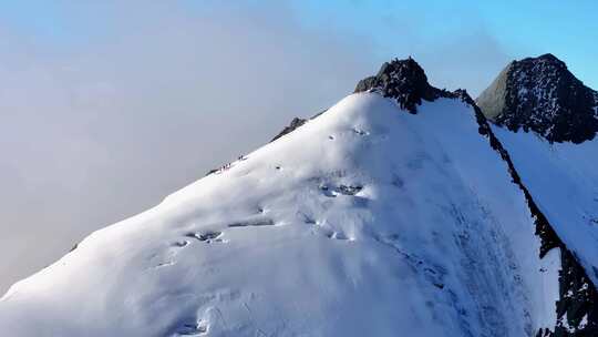 航拍攀登横断山脉乌库楚雪山山脊上的登山者