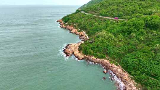 海岸边绿意盎然的山景与平静海面