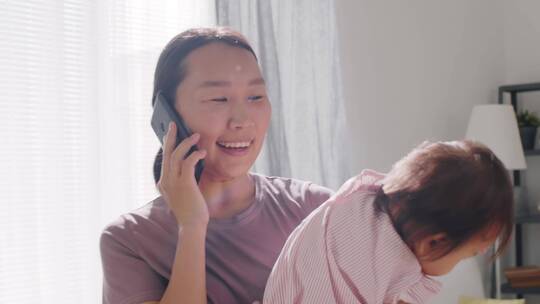 抱着女儿接电话的母亲视频素材模板下载