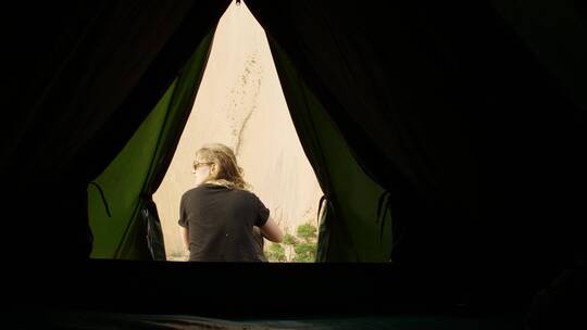 女人坐在帐篷外面视频素材模板下载