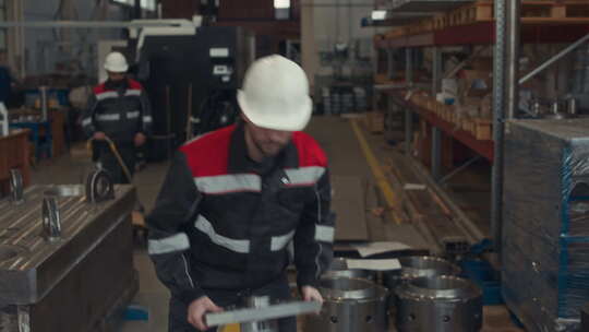 沿着工业工厂搬运重型机械细节的男技术员视频素材模板下载