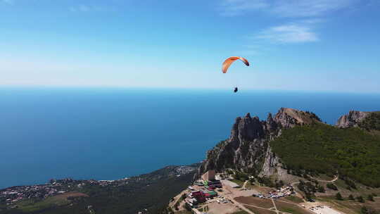 在美丽山峰的背景下，滑翔伞在滑翔伞上飞行