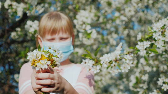 戴着口罩的女孩正捧着一束花
