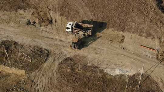 挖掘机将土壤装入卡车后部