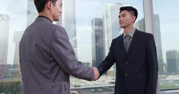 成功商务人士握手看向远方畅聊