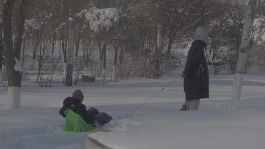 男子在雪地上坐着简易冰车