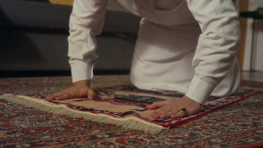 宗教穆斯林男子在家中的祈祷地毯上多次跪拜视频素材模板下载