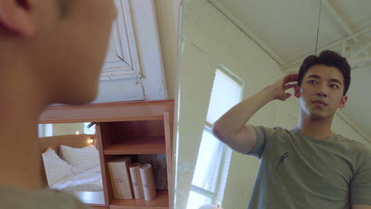 年轻男人照镜子整理发型视频素材模板下载