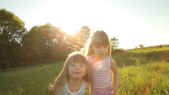 两个女孩在田野上奔跑玩闹
