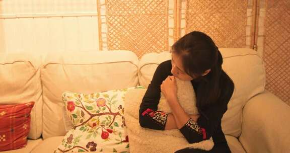 女人沙发上抱抱枕沉思