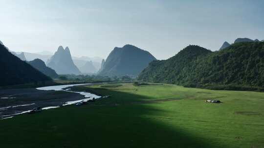 阳光下桂林山谷中的河流草地和露营基地