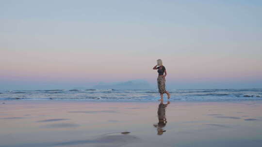 年轻人在黄昏的海边漫步