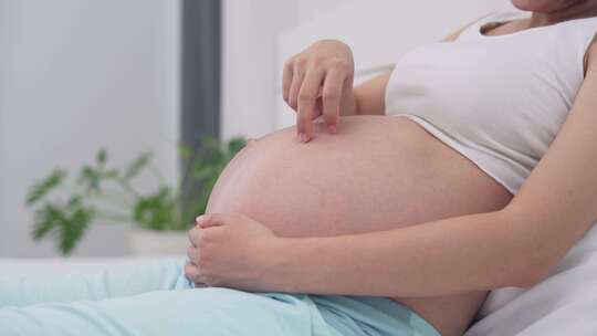 孕妇妈妈抚摸着自己的肚子期待宝宝出生视频素材模板下载