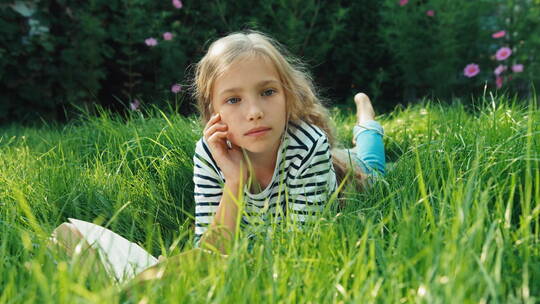 孩子在草地上看书听音乐