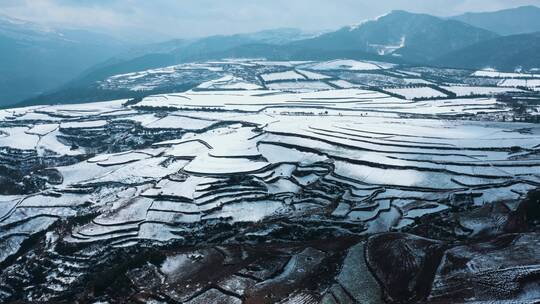 冬季白雪覆盖山川线条明显田野远处连绵雪山