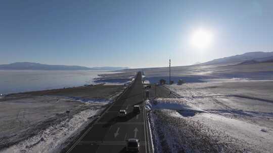 航拍冬季新疆赛里木湖环湖车辆行驶雪山公路视频素材模板下载